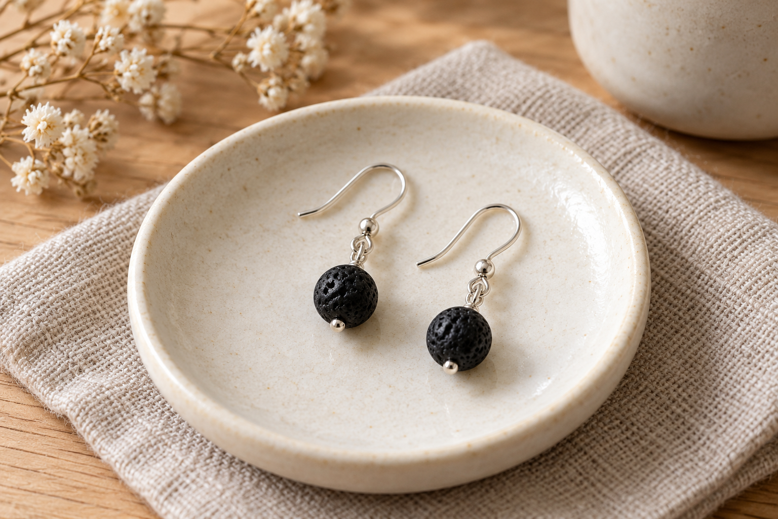 Paire courte de boucles d’oreilles en pierre de lave sur crochets, illustration.