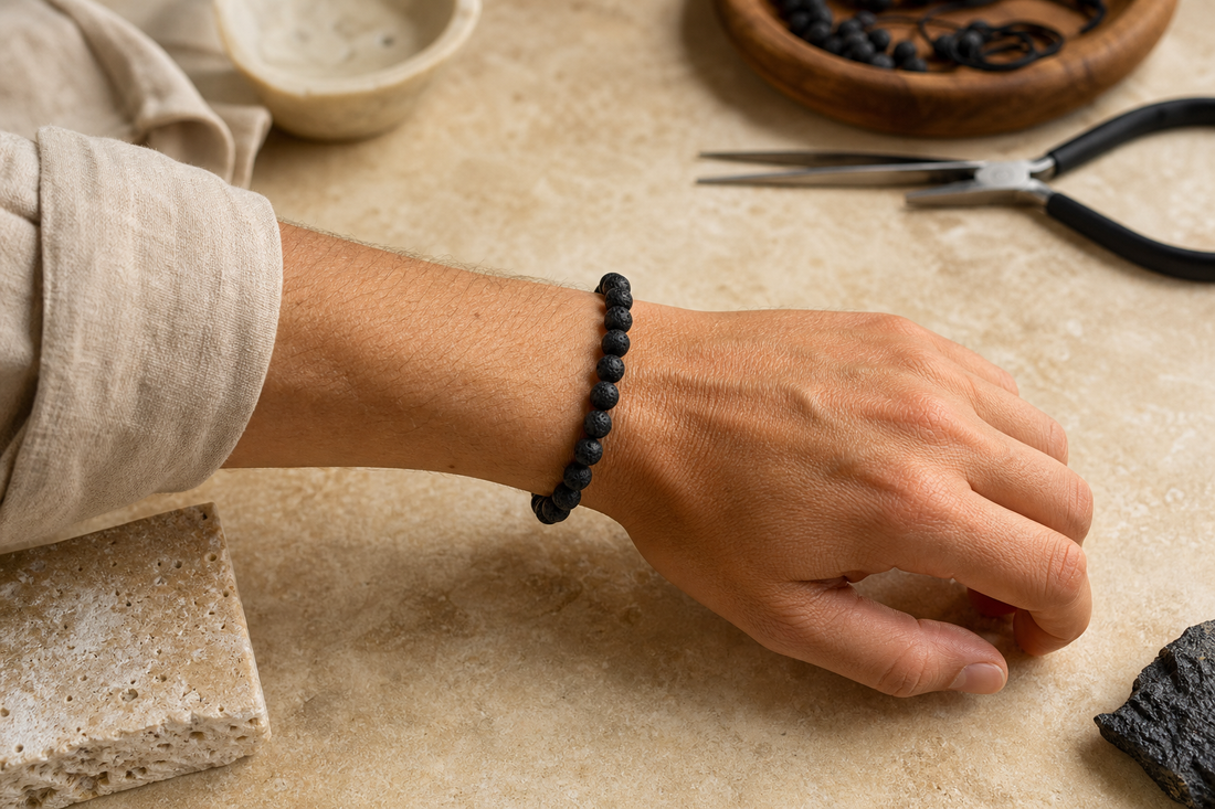 Bracelet fini en perles de lave porté au poignet sur un établi de bijoutier