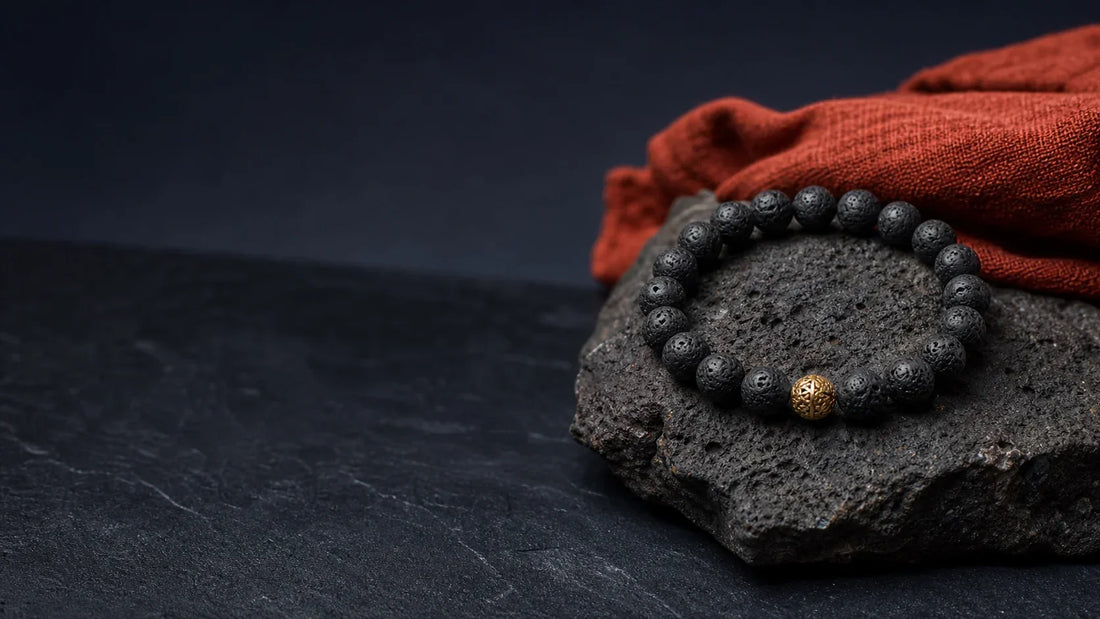 Bracelet en pierre de lave sur roche volcanique, évocation symbolique de l’ancrage
