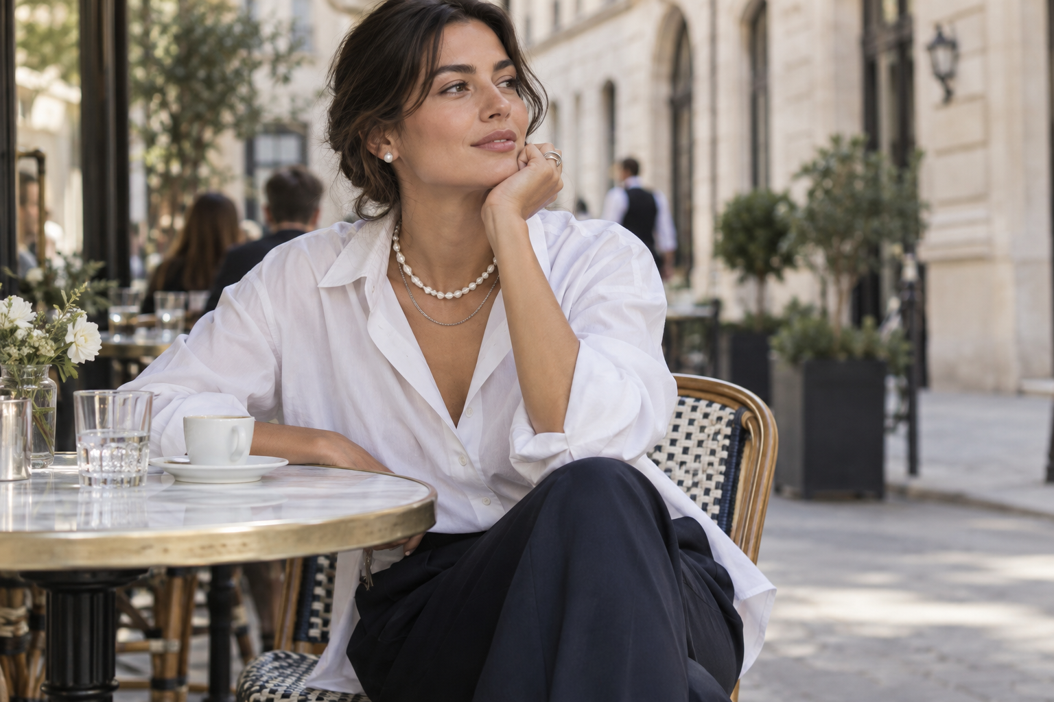 Collier de perles irrégulières superposé à une chaîne sur une chemise blanche contemporaine
