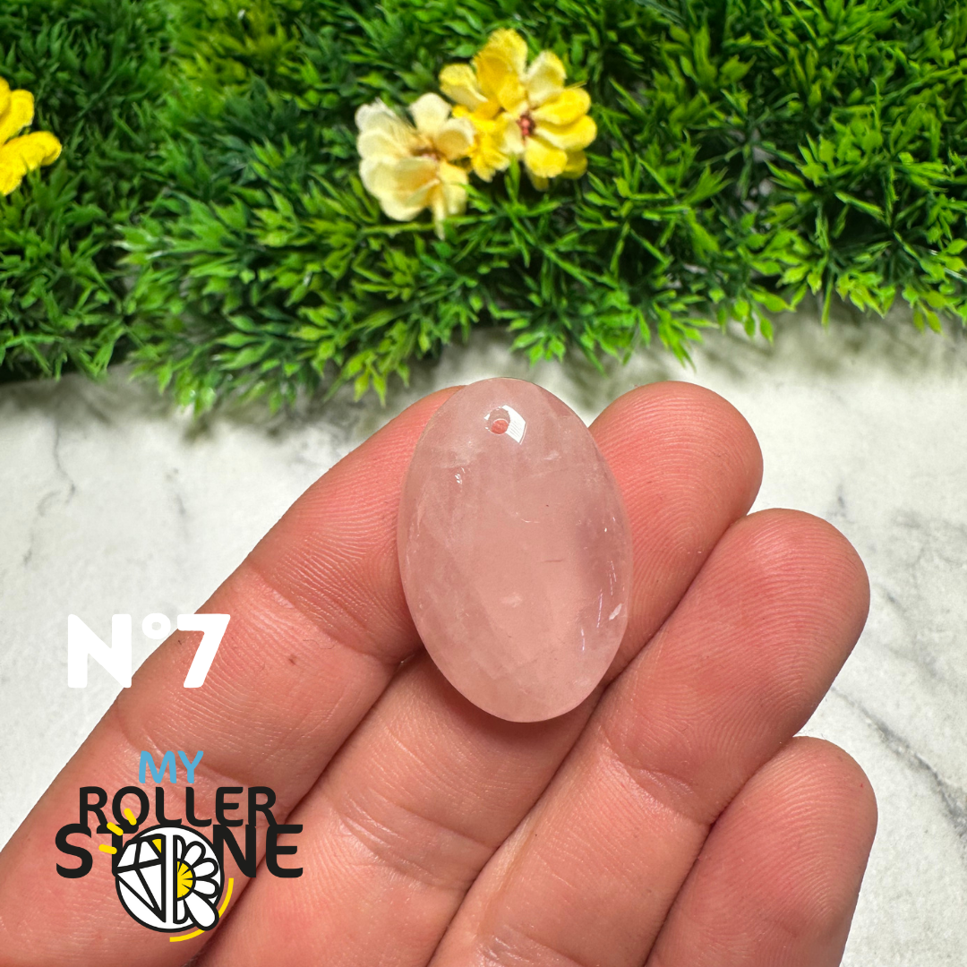 Pierre de quartz rose percée et polie observée sur fond clair